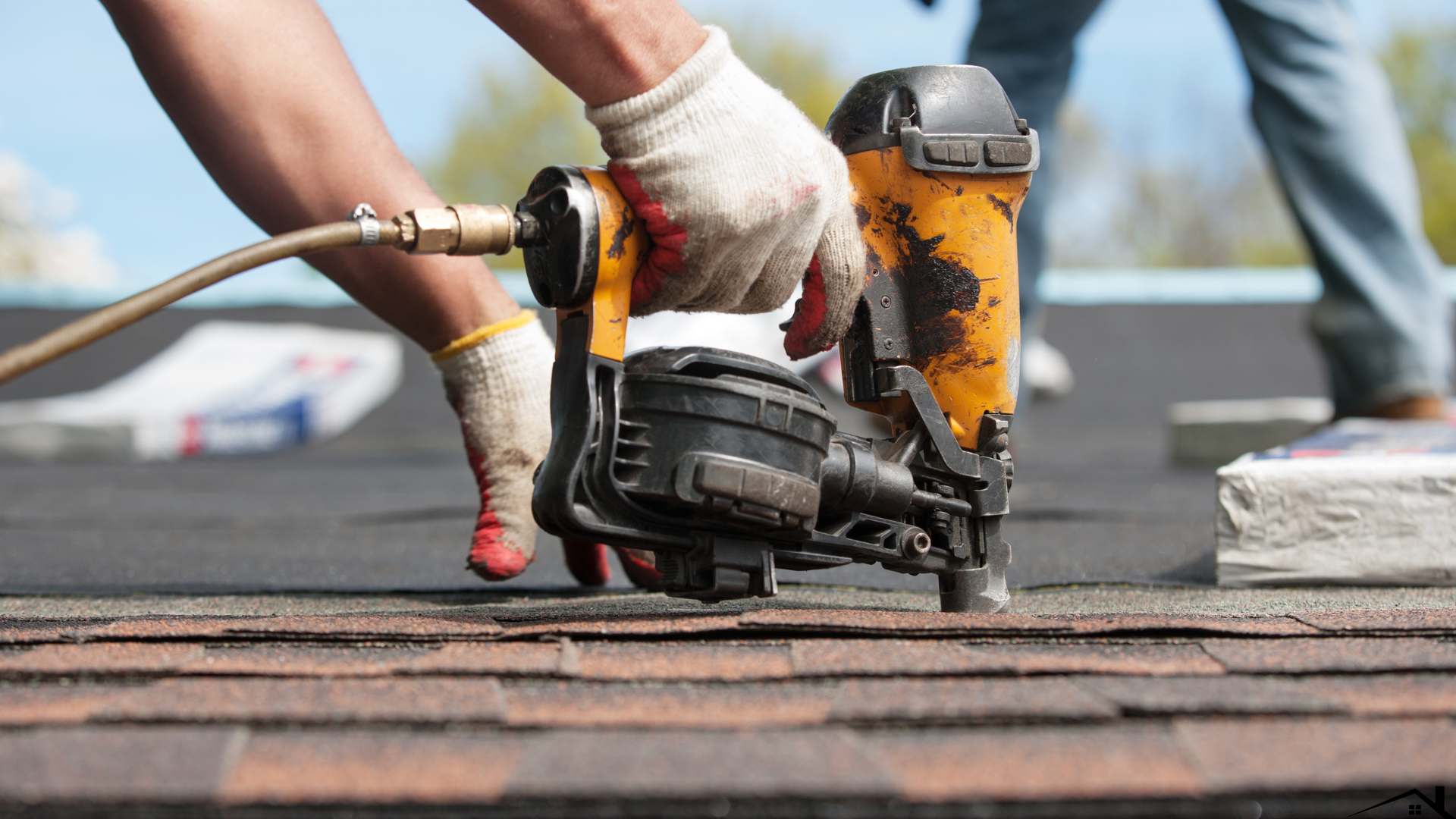 Roofer nailing shingles on a roof
